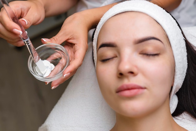 Closeup shot of a woman getting facial treatment with clay mask Cosmetology and spa