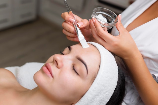 Closeup shot of a woman getting facial treatment with clay mask Cosmetology and spa