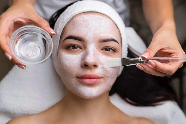 Closeup shot of a woman getting facial treatment with clay mask Cosmetology and spa