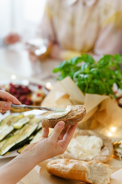 Closeup shot of a woman making a cream cheese sandwich at the festive table