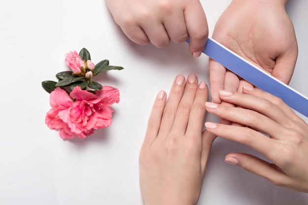 Closeup shot of a woman in a nail salon Beautician file nails to a customer