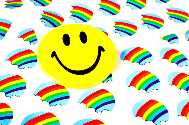 Closeup shot of a yellow smiley face on a rainbow wall background