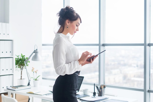 Closeup side view portrait of an employee texting sending and reading messages during her break at the workplace