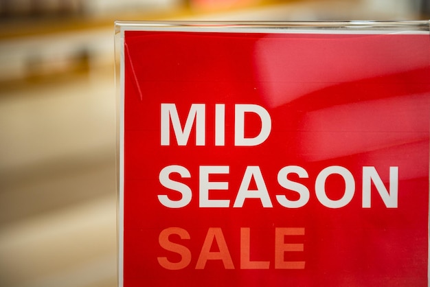 Closeup of sign in shopping mall advertising mid season sale and discounts