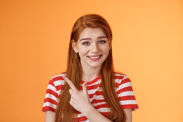 Photo closeup silly cute redhead female trying help showing way smiling friendly politely introduce promo ...