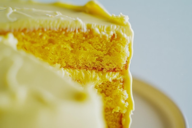 Photo a closeup of a slice of yellow cake with rich creamy frosting capturing its soft moist texture and decadent appeal