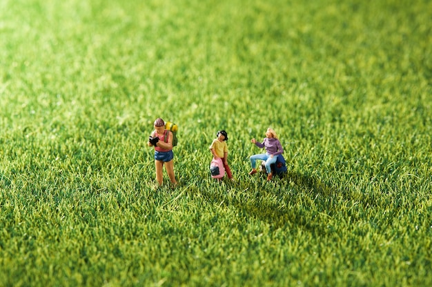 Closeup of small miniature plastic people on a grass surface