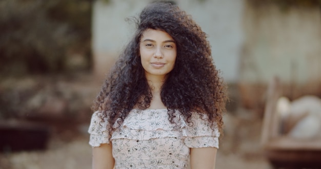 Closeup of a smiling young latin afro woman. Joy, positive and love. Beautiful african-style hair