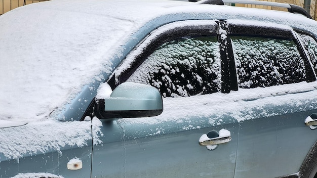 Closeup of snow covered  suv car under blizzard Cold winter frosty snowy background