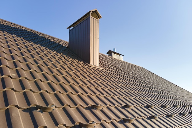 Closeup snow guard for safety in winter on house roof top covered with steel shingles Tiled covering of building