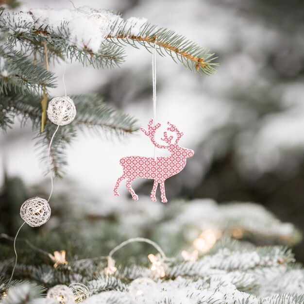 Closeup of snowy evergreen tree with nice Christmas decorations in the winter forest