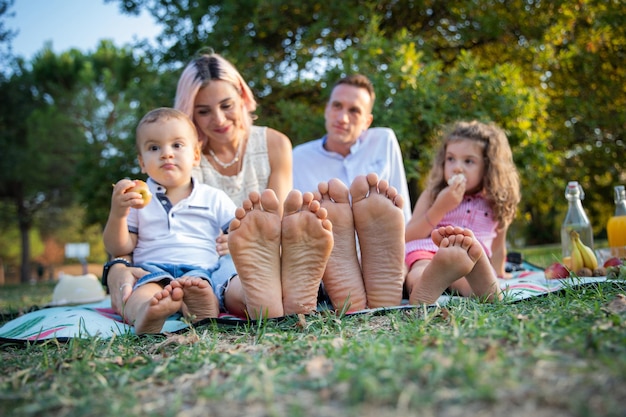 Closeup of the soles of the feet of a family during a picnic in a park