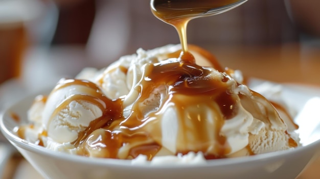 Photo closeup of a spoon drizzling caramel sauce over vanilla ice cream