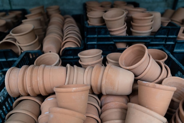 Closeup of stacks of old used weathered terra cotta flower pots in gardening shed