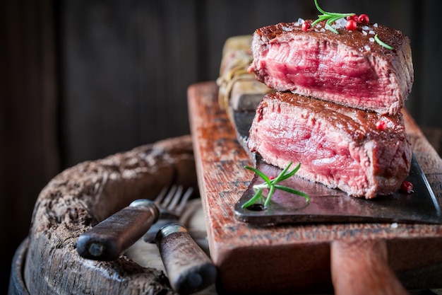 Closeup of steak with rosemary and salt on wooden plank