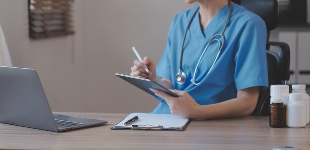 Closeup of stethoscope and paper on background of doctor and patient hands