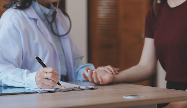 Closeup of stethoscope and paper on background of doctor and patient hands