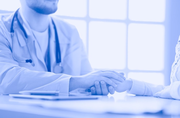 Closeup of stethoscope and paper on background of doctor and patient hands