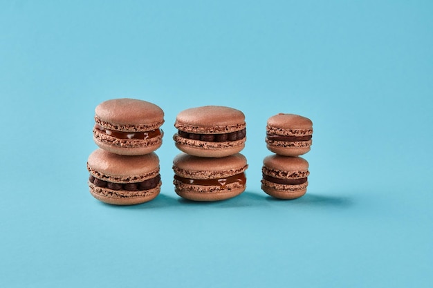 Closeup studio shot of tasty chocolate macarons on blue background