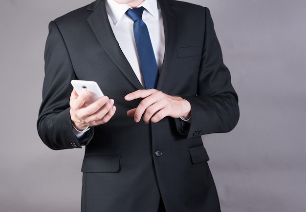 Closeup of a successful businessman using mobile smart phone