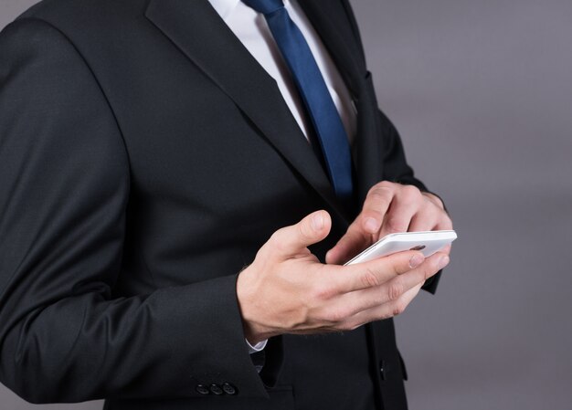 Closeup of a successful businessman using mobile smart phone