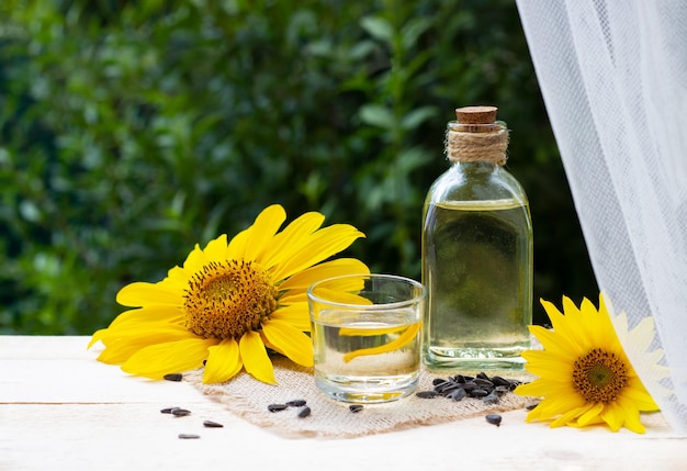 Closeup of sunflower oil in a bottle glass with seeds and sunflower