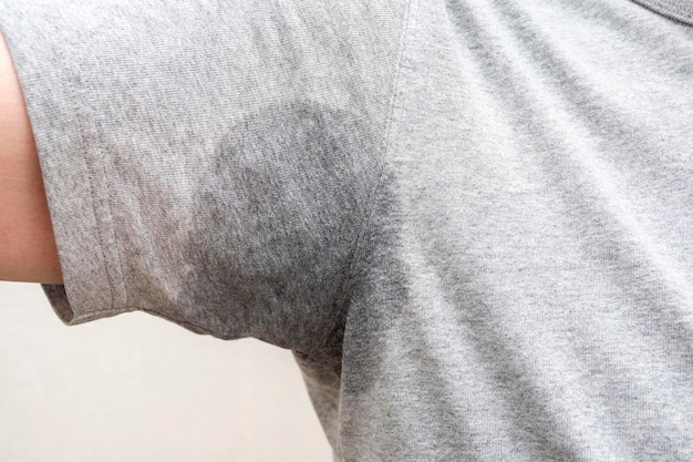 Closeup of sweaty armpit wet underarm wet stain on grey tshirt