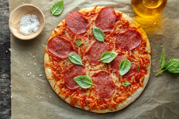 Closeup of tasty appetizing salami pizza with cheese and spices.