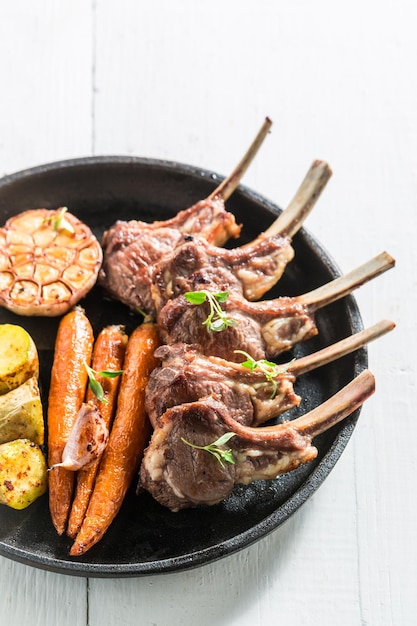 Closeup of tasty grilled ribs of lamb on white table