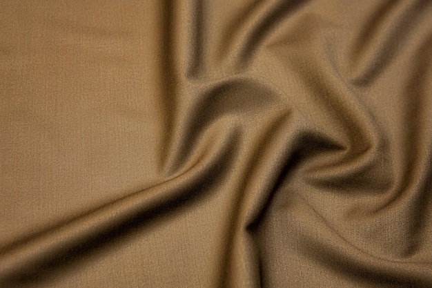 Closeup texture of natural beige fabric or cloth in brown color Fabric texture of natural cotton or linen textile material Beige canvas background