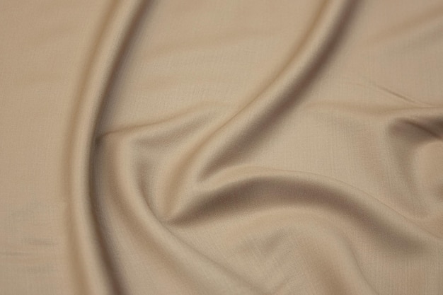 Closeup texture of natural beige fabric or cloth in brown color Fabric texture of natural cotton or linen textile material Beige canvas background