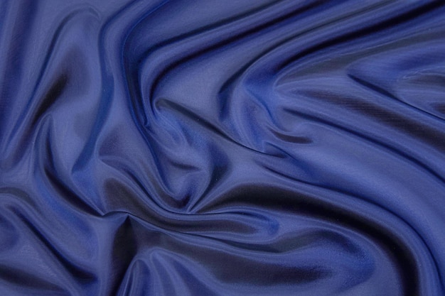 Closeup texture of natural blue fabric or cloth in same color Fabric texture of natural cotton silk or wool or linen textile material Blue canvas background