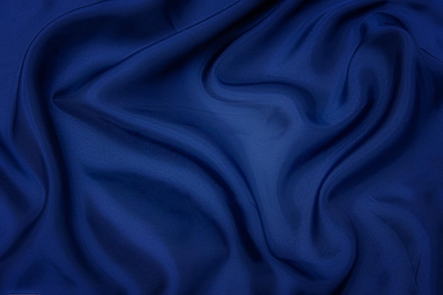 Closeup texture of natural blue fabric or cloth in same color Fabric texture of natural cotton silk or wool or linen textile material Blue canvas background