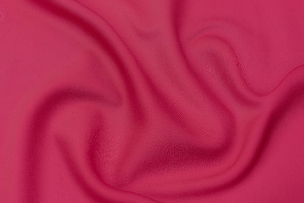 Closeup texture of natural red or pink fabric or cloth in same color Fabric texture of natural cotton silk or wool or linen textile material Red and orange canvas background