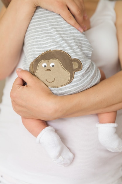 Closeup of tiny baby in socks in the hands of his mother