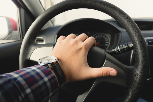 Closeup toned photo of male driver honking the horn