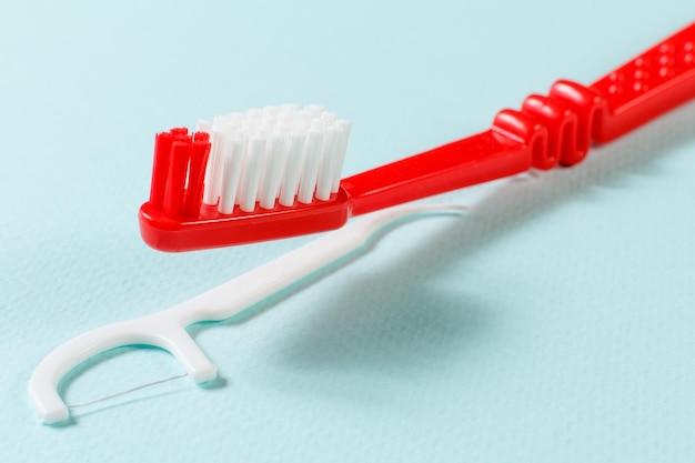 Closeup toothbrush and flossing toothpick on the blue background