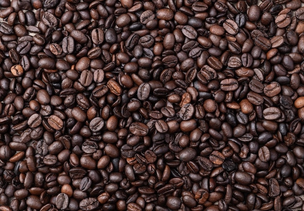 Closeup top view of coffee beans over rustic wooden table