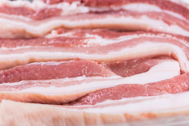 Closeup top view pieces fresh raw meat of pork belly with white fat and red pink meat