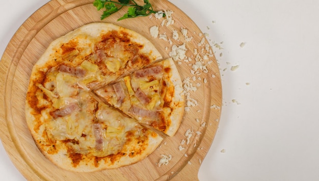 Closeup top view studio shot of tasty delicious Italian homemade mozzarella cheesy ham pineapple original Hawaiian pizza soft bread crust on wodden plate served on table in restaurant