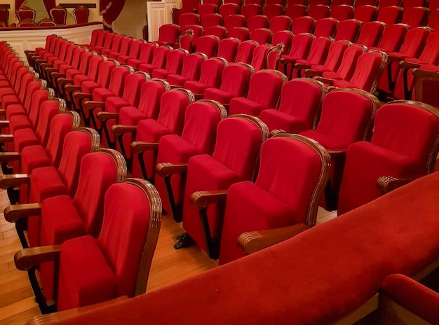 Closeup of traditional classic empty chairs upholstered in red velvet the interior of the theater