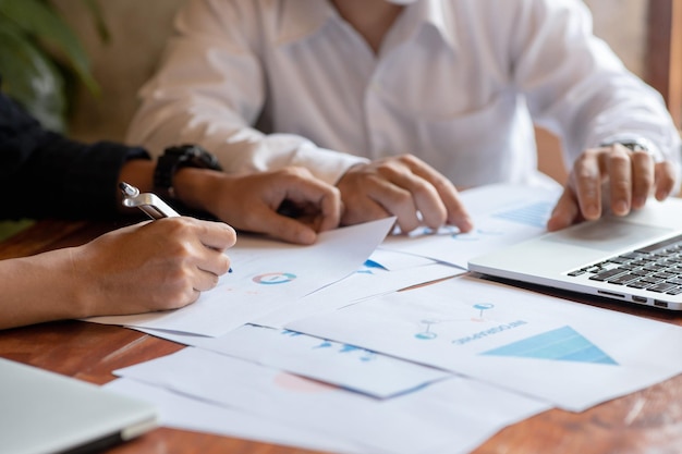 Closeup of two business people meeting to analyze and plan investment marketing financial report data on the table in office