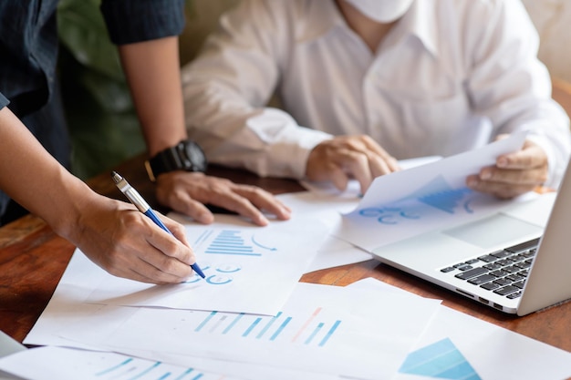 Closeup of two business people meeting to analyze and plan investment marketing financial report data on the table in office