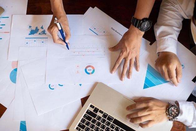 Closeup of two business people meeting to analyze and plan investment marketing financial report data on the table in office