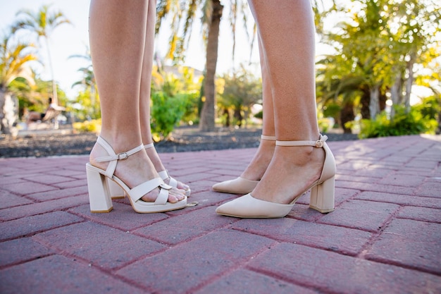 Photo closeup of two women's feet wearing heels in a public park