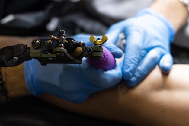 Closeup of an unrecognizable tattoo artist tattooing