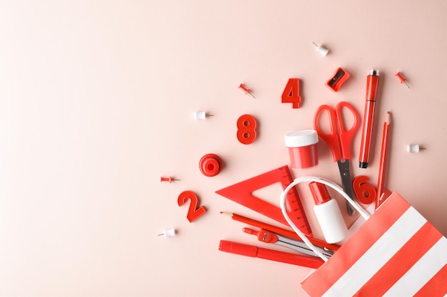 Closeup of various red stationery lying on a beige background