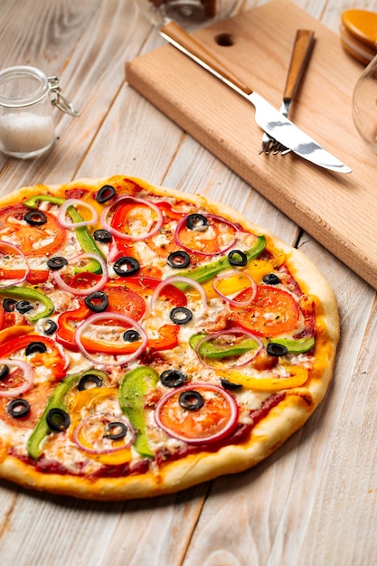 Closeup on vegetable pizza with olives and pepper