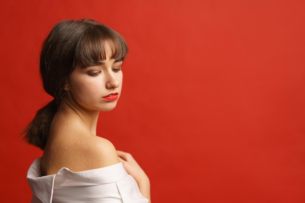 Closeup view attractive sexy passionate girl standing in studio in white shirt