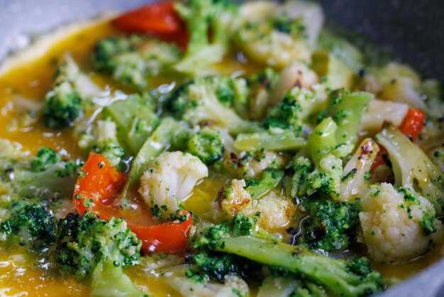 Closeup view of frying vegetables with egg yolks with selective focus and background blur